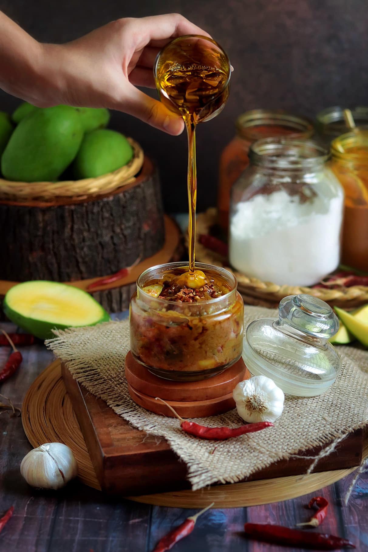 A person pouring an oil on a spicy jar